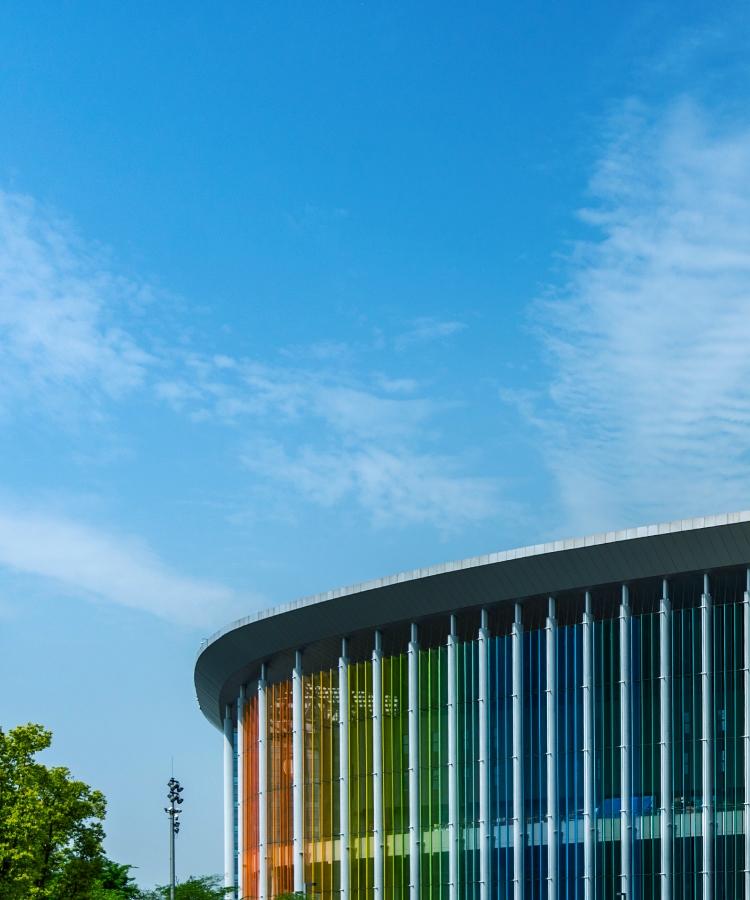 Vista externa de um centro de exposições moderno com painéis de vidro coloridos, que abriga a apresentação da Solavita e destaca a inovação em soluções de energia renovável