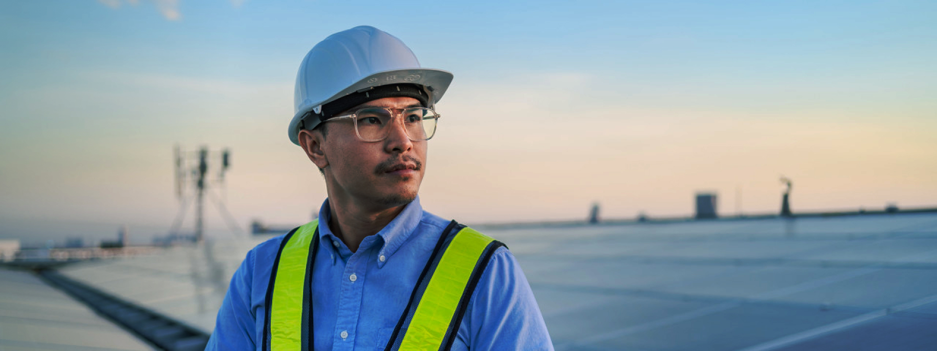 Engineer in safety gear inspecting Solavita inverter installation on a solar panel array, focused on ensuring optimal system performance.